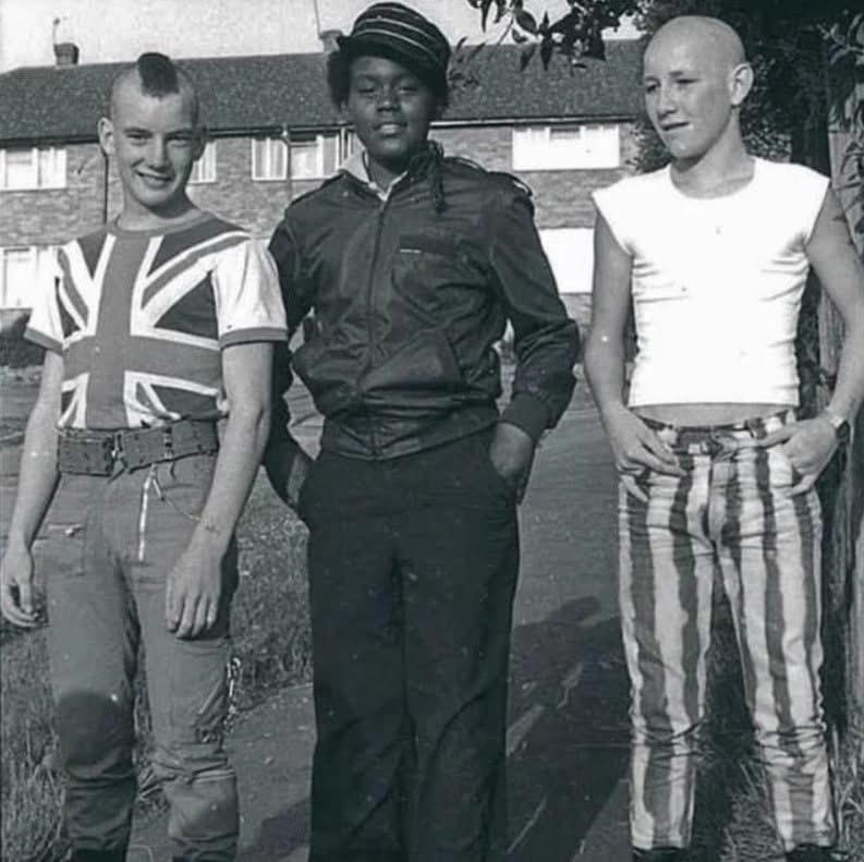 大约1980年，英国，一个朋克、一个鲁德男孩（rude boy）和一个光头党（skinhead）聚在一起。