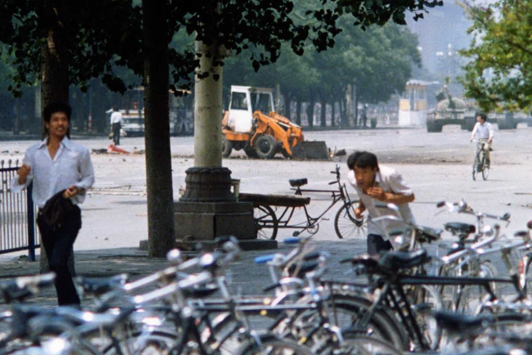 从地面视角拍摄的“坦克人”，透过左侧的树木隐约可见。1989年6月5日。