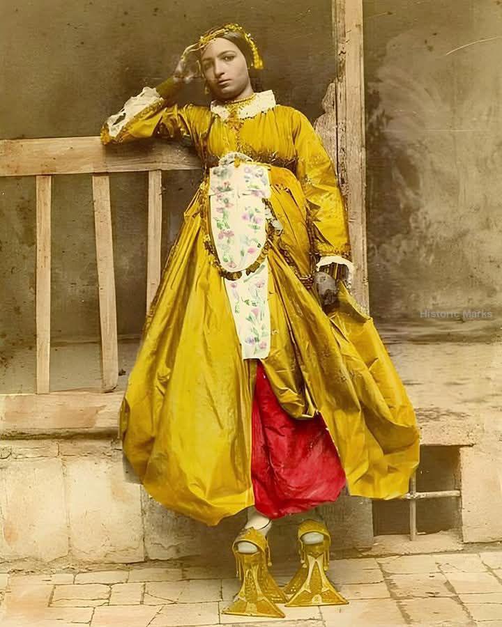 这张手工上色的照片拍摄于1865年，展现了一位身着传统服饰的叙利亚大马士革犹太女孩。