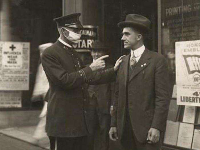 旧金山一名警察在1918年流感大流行期间（1918年），训斥一名未戴口罩的男子。[700x525]